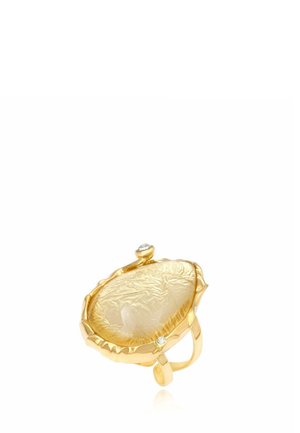 Bague en or avec une grande pierre précieuse jaune translucide texturée et deux petits pierres d'accent claires sur la monture.