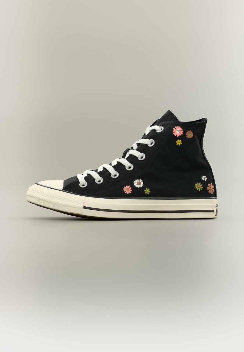 Μαύρο υψηλό αθλητικό παπούτσι με λευκά κορδόνια και σόλα, διακοσμημένο με μικρά πολύχρωμα κεντημένα λουλούδια στο πλάι.