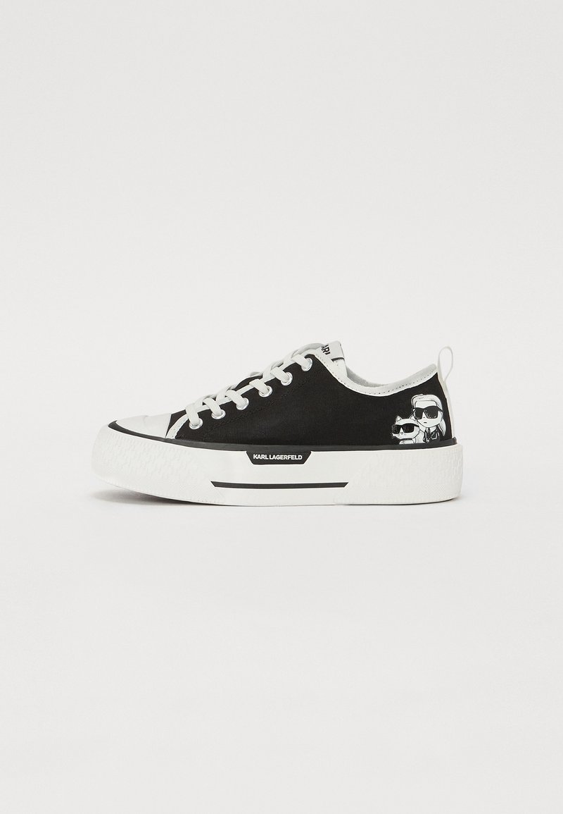 Baskets basses noir et blanc avec lacets blancs, semelle épaisse, étiquette "Karl Lagerfeld" et dessins animés près du talon.