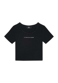 Crop top noir à manches courtes côtelé avec un col rond et le texte "LE TEMPS DES CERISES" imprimé sur la poitrine.