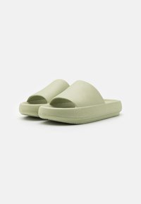 Sandale slip-on de culoare verde deschis, cu o parte superioară texturată, design cu vârf deschis și o talpă groasă, captusită pentru confort și suport.