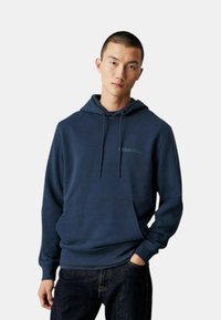 Felpa blu navy realizzata in tessuto morbido, con tasca frontale, collo con cordino e discreto logo ricamato di Calvin Klein sul petto.