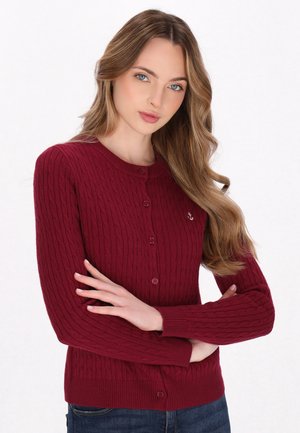 Burgundy ribbed cardigan with a round neckline, button closure, and anchor emblem on the left chest. Cotton blend material, slim fit.