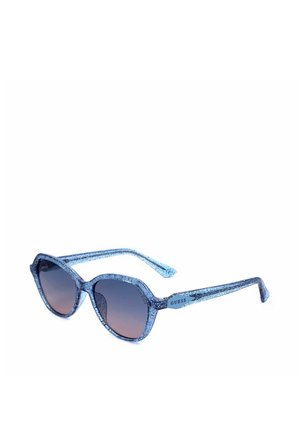 Occhiali da sole a occhi di gatto blu glitterati con lenti a gradiente scuro e nome del marchio "Guess" sulle aste.