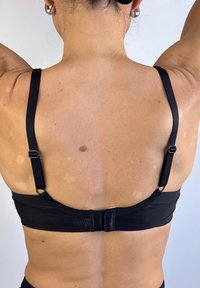 Sujetador deportivo negro con tirantes ajustables y cierre de gancho en la parte posterior. Fabricado con una tela suave y elástica, con un diseño limpio y minimalista.