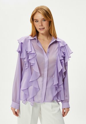 Lichtpaarse blouse met ruches op de schouders en aan de voorzijde, met knoopjes en lange mouwen. Gemaakt van doorschijnend, lichtgewicht stof.