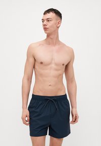 Pantaloni da mare a righe blu navy con vita elastica e cordino. Realizzati in tessuto leggero, progettati per comfort e mobilità.