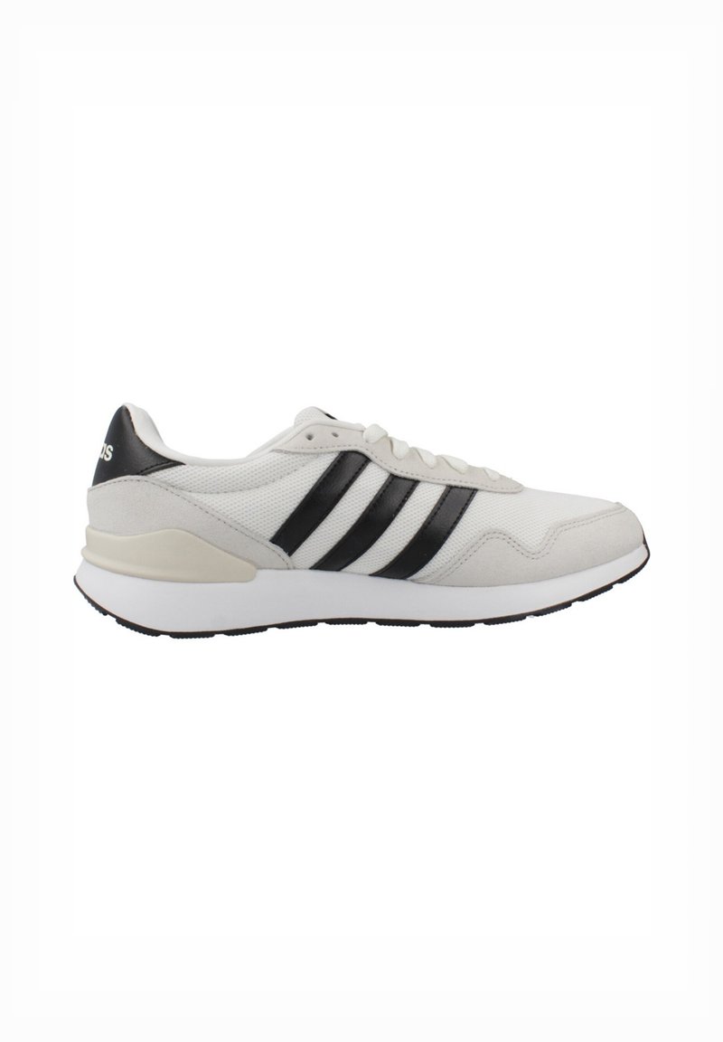 White athletic shoe with black stripes, mesh and suede materials, rounded toe, padded collar, and textured sole for grip.