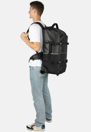 Schwarzer Rucksack mit seitlichen Rollen, mehreren verstellbaren Riemen und einem stabilen Griff, hergestellt aus strapazierfähigem Material. Verfügt über ein elegantes, funktionales Design.