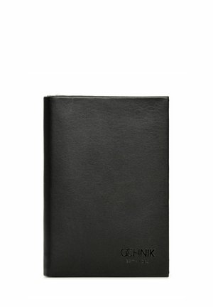 Czarna skórzana teczka o gładkiej fakturze, kwadratowym kształcie, z wytłoczonym logo na dole i minimalistycznym designie. Brak widocznych zapięć lub ozdób.