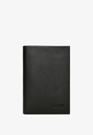 Czarna skórzana teczka o gładkiej fakturze, kwadratowym kształcie, z wytłoczonym logo na dole i minimalistycznym designie. Brak widocznych zapięć lub ozdób.