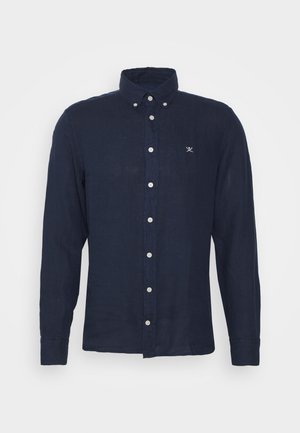 Námořnická modrá košile s dlouhými rukávy, na knoflíky, s límcem na knoflíky a malým bílým logem křížených veslařských pádel na levé hrudi.