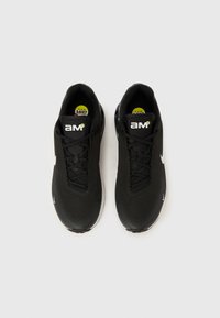 Mustad spordijalatsid võrgust pealmise osaga, tekstureeritud pinnaga ja logodega. Omavad polsterdatud talla ning paelaga kinnitust.