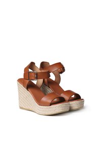Sandali con tacco wedge in pelle marrone, dotati di due fasce larghe e una fibbia. Piattaforma avvolta in juta con finitura texturizzata. Design con retro chiuso per maggiore supporto.
