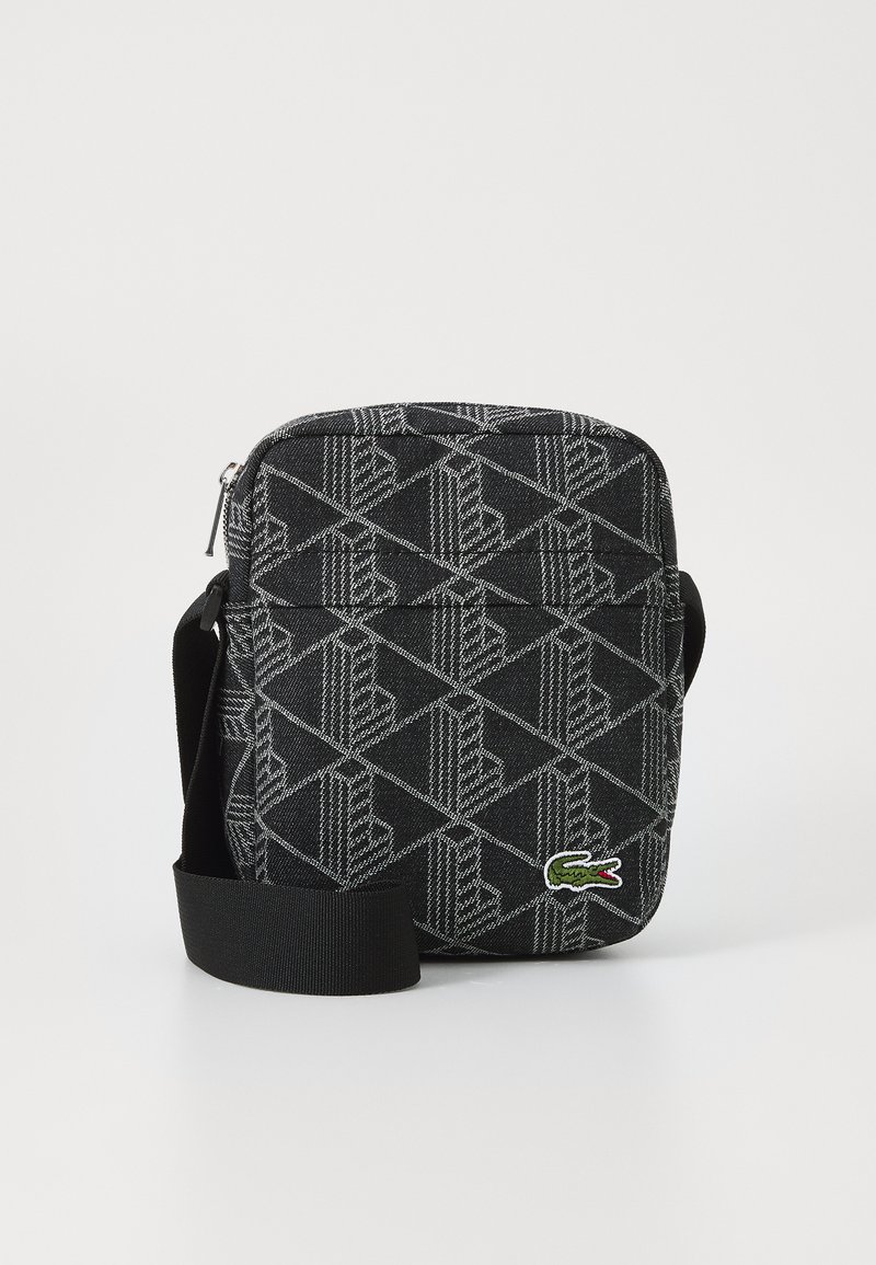 Borsa a tracolla nera con motivo geometrico, tasca anteriore con zip, tracolla in tessuto e logo coccodrillo verde ricamato.
