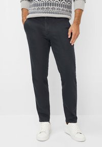 Donkergrijze chino's van een katoenmix, met een recht gesneden ontwerp, subtiele textuur en zijzakken. Gecombineerd met witte sneakers.