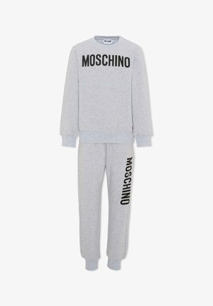 Tuta due pezzi grigio chiaro con scritta nera "MOSCHINO" sul petto della felpa e stampata verticalmente sulla gamba sinistra dei pantaloni.