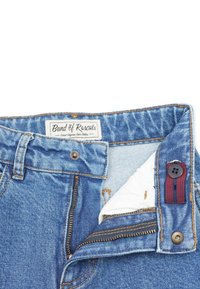 Jeans i denim med blåtvätt, med dragkedja, kopparfärgad hårdvara och en tygetikett sydd på insidan av midjebandet.