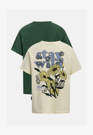 To T-shirts med korte ærmer, en mørkegrøn og en cremefarvet med teksten "stay wild" og et gult blomsterdesign med smilende ansigter på ryggen.