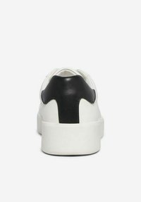 Sneaker bianco con un accentuato tallone nero imbottito, tomaia in pelle liscia, punta rotonda e suola in gomma spessa. Design minimalista.
