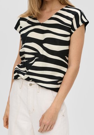 Sort-hvidstribet bluse med V-hals og kapærmer, lavet af letvægtsstof, vist med lyse, højtaljede bukser.