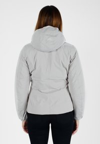 Giacca a vento imbottita grigia chiara con cappuccio, caratterizzata da un design aderente e polsini elasticizzati, vista da dietro. Tessuto dalla texture liscia.