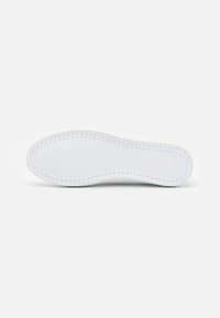 Semelle de chaussure en caoutchouc blanc avec une surface texturée présentant un motif en grille. Bords arrondis et finition lisse.