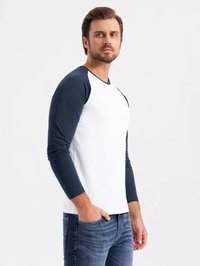 Langærmet raglan t-shirt med hvid krop og marineblå ærmer. Blødt bomuldsstof med en afslappet pasform. Jeans synlige ved taljen.