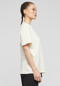 Kortærmet, off-white t-shirt lavet af bomuld, med en afslappet pasform, rund hals og ventilerede sidesømme for åndbarhed.