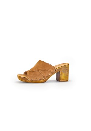 Braune Wildleder-Mule mit Blockabsatz, wavy Design und dekorativen Metallnieten entlang der Kante. Mit offenem Zehenbereich und Holzabsatz.