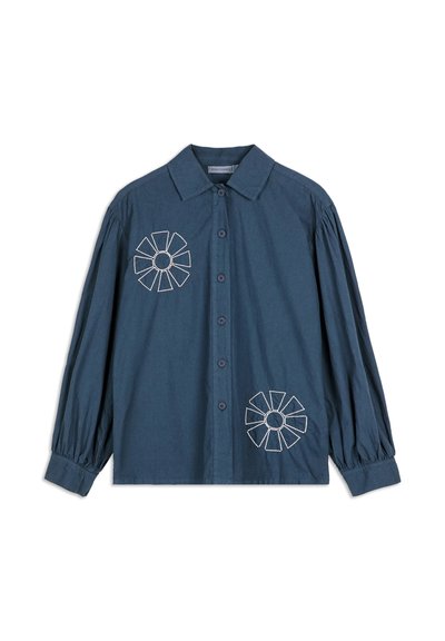 Camicia blu scuro a maniche lunghe con colletto, polsini arricciati e motivi floreali geometrici ricamati di colore bianco sul petto e sul lato inferiore.