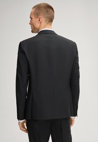 Schwarze Anzugjacke mit maßgeschneidertem Schnitt, Zwei-Knopf-Verschluss, gekerbtem Revers und vier Knopf-Ärmeldetails. Glatter, strukturierter Stoff.