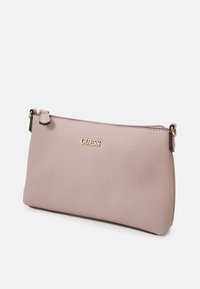 Pochette en cuir texturé rose avec un logo doré. Elle dispose d'une fermeture éclair et d'accents en matériel décoratif. Sa forme rectangulaire compacte.