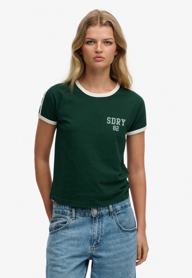 Groen T-shirt met korte mouwen, voorzien van een witte geribbelde halslijn en zoom, met de tekst "SDRY 82" in het wit aan de linkerkant.