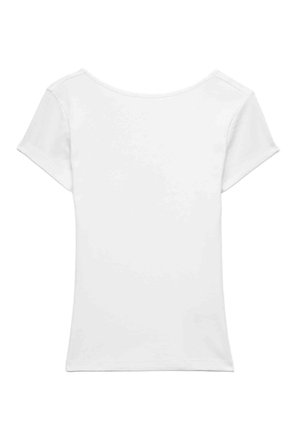 Kvinde iført en simpel hvid tætsiddende t-shirt med korte ærmer og lyseblå jeans, med gyldne creoløreringe og løst brunt hår.