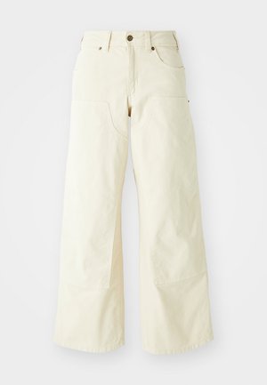 Bežīgas plašas bikses, izgatavotas no kokvilnas, ar augstu jostasvietu, lielām priekšējām kabatām un gludu tekstūru ar minimālu šuvju detaļu.