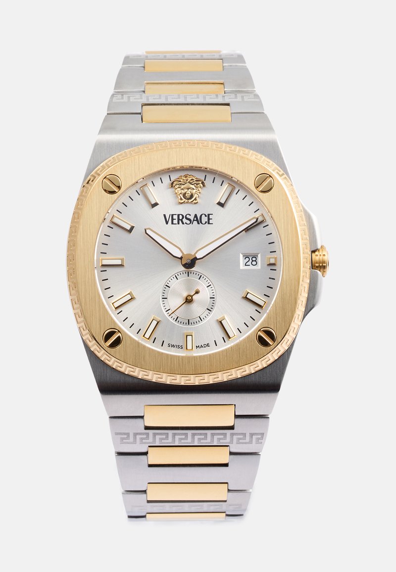 Orologio Versace con bracciale in acciaio inossidabile e tonalità oro. Cassa quadrata, quadrante argentato, indici delle ore dorati e logo leone alle 12.