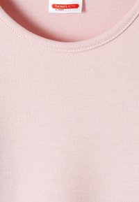 Haut thermique rose clair avec un col rond, fabriqué à partir d'un tissu en tricot doux. Présente une étiquette portant la mention "THERMOLACTYL par DAMART."