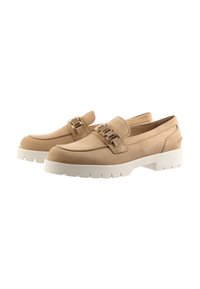 Mocassins en daim beige avec des accents en métal doré, dotés d'une épaisse semelle blanche et de coutures sur le dessus pour plus de texture.