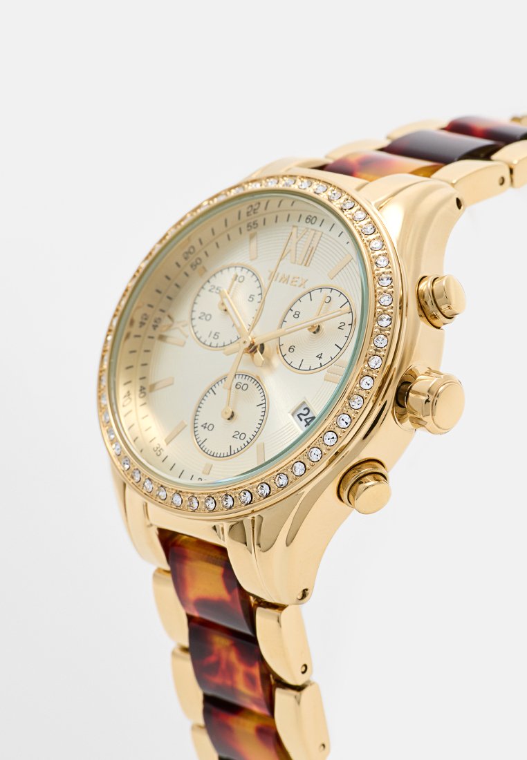 Reloj cronógrafo de tono dorado con una pulsera de eslabones de carey, que presenta un bisel con cristales y una esfera en color champán claro con tres subesferas.