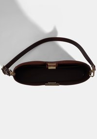 Bordeaux leren handtas met een gestructureerde vorm, gouden hardware en een afneembare schouderriem. De binnenkant is gevoerd met zwart.