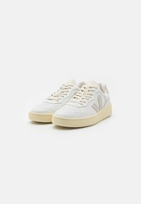 Witte sneakers met een glad leren bovenwerk, perforaties, beige accenten en een gestructureerde rubberen zool. Schoon, minimalistisch ontwerp.