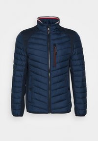 Marineblaue gesteppte Jacke mit Stehkragen, Frontreißverschluss, Reißverschluss-Brusttasche und zwei Seitentaschen mit Knopfverschlüssen.