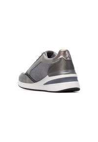 Zapatilla deportiva gris que presenta una mezcla de materiales suaves y texturizados, una suela acolchada y detalles metálicos en el talón.