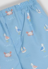 Hellblaue Shorts aus glattem Stoff, verziert mit mehrfarbigen Mustern von Möwen, Krabben und Segelbooten. Mit einem elastischen Bund oben.