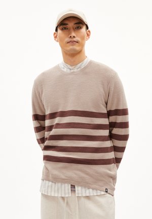 Strickpullover in hellem Beige mit horizontalen weinroten Streifen. Hat einen Rundhalsausschnitt und einen gestuften Look mit einem darunter liegenden Hemd mit Kragen.