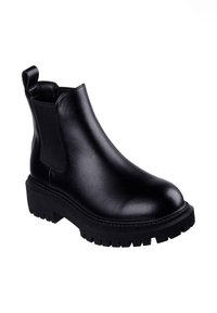 Bota de tobillo de cuero negro con acabado liso, paneles laterales elásticos y suela gruesa de goma con profundas ranuras para tracción.