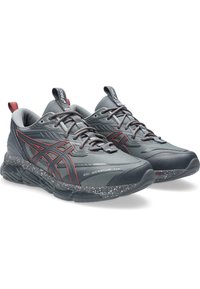 Scarpe da ginnastica grigie con accenti rossi, dotate di una parte superiore testurizzata, suola ammortizzata e dettagli riflettenti. Inclusa la tecnologia di ammortizzazione in gel.