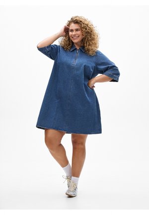 Jeansklänning med dragkedja i halsringningen, korta ärmar, lös passform och utsvängd design. Tyget är medelblått med en slät textur.