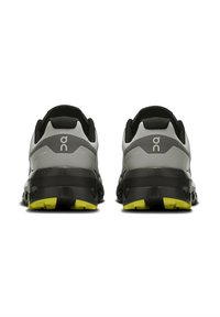 Graue und schwarze Laufschuhe mit einer strukturierten Gummisohle; gelbe Akzente auf der Außensohle; gepolstertes Fersendesign.